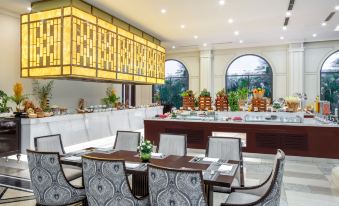 a dining room with a long table and several chairs , as well as a buffet table filled with various food items at Melia Vinpearl Cua Sot Beach Resort