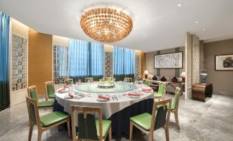 There is a large dining room with round tables and chairs in the center, as well as other features at Crowne Plaza Guangzhou City Centre