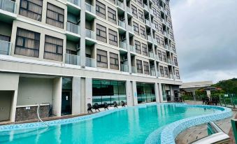 a large swimming pool is located in front of a modern hotel building with multiple balconies at Livingston Hotel