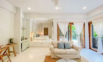 a large , modern living room with a beige couch and sliding glass doors leading to a balcony at Proud Phu Fah Maerim Resort