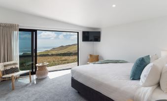 a bedroom with a large bed , a television , and a window overlooking a beautiful view at Castaways Resort