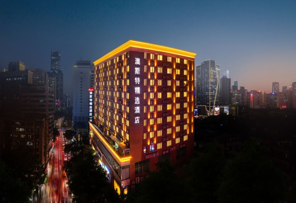 A city hotel is shown in a time-lapse video at night, featuring neon lights on all sides at Guangzhou Zhujiang New Town Ausotel Smart Hotel, Canton Fair Free Shuttle