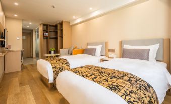 A bedroom with two beds and an attached bathroom is available for the children to sleep in at Hongge Apartment Hotel