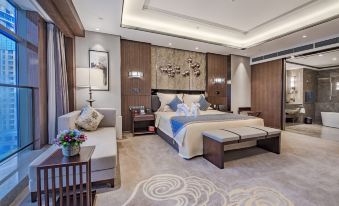 The middle room features a spacious bed with a sitting area and a table on each side at Hainan Grand Hotel