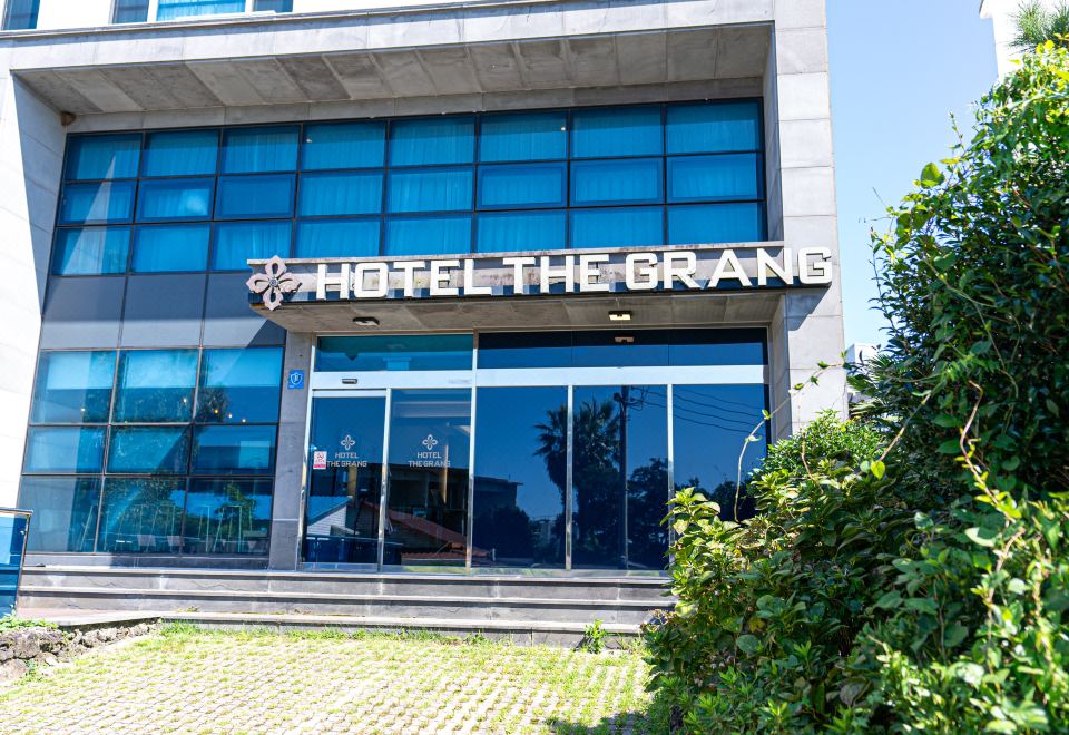 The front entrance of a hotel displays signs in both Chinese and Japanese languages at Hotel the Grang Jungmun