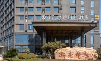 The front view and entrance of a large building in an urban setting with parking lots on both sides at Zhedong Chuyue International Hotel