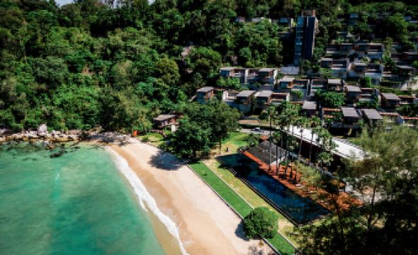 aerial view of a tropical resort surrounded by lush greenery , with a beach visible in the background at The Naka Phuket, a member of Design Hotels