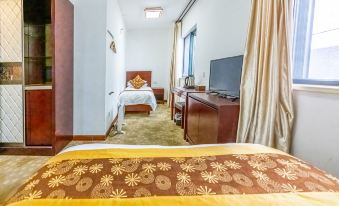 The room is unfurnished and contains two beds, a TV, and a desk in the center at Guangmingding Hotel