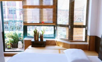 A bedroom with large windows offers an outside view of the living area and includes a bed at CITY PARK HOTEL