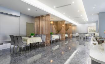 The restaurant features spacious tables and chairs arranged in the center, creating an open concept dining area at Capital Airport International Hotel