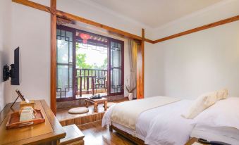 a cozy bedroom with wooden furniture , white bedding , and a window offering a view of the outdoors at Riverview Hotel