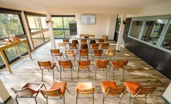 a large room filled with rows of wooden chairs arranged in a semicircle , possibly for a meeting or event at Le Bois d'Imbert