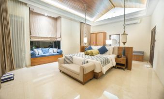 a modern bedroom with a large bed , wooden furniture , and a sliding glass door leading to a balcony at The Singhasari Resort Batu