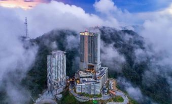 an aerial view of the city and its surrounding buildings, featuring a spacious green field at MagTree Genting Highlands