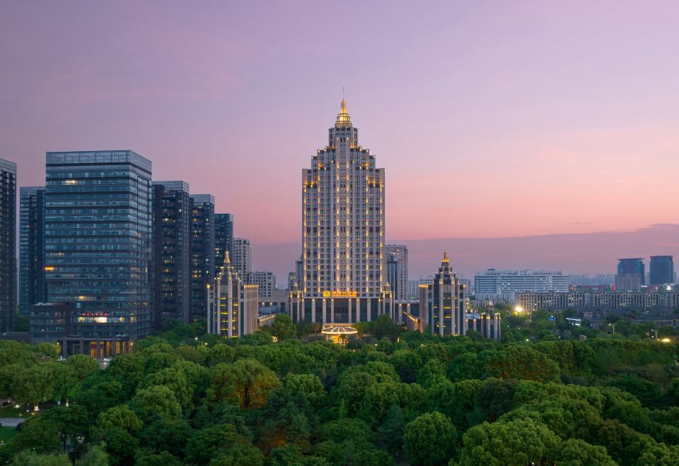 A city with a skyline and an illuminated building at dusk at Inspirock Hotel