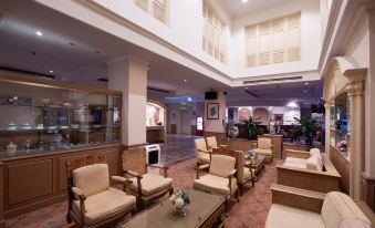 a large hotel lobby with several chairs and couches arranged for guests to relax and socialize at The Imperial Narathiwat Hotel