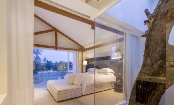 a large bedroom with a bed , couch , and sliding glass doors leading to an outdoor area at Sala Ayutthaya