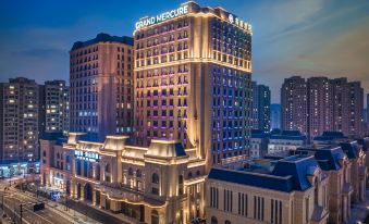 At night, a city is illuminated by blue and white lights on top of its buildings at Grand Mercure Hangzhou Zijingang