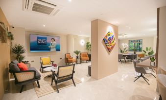 A spacious lobby or reception area in an apartment complex furnished with chairs and tables at Coliwoo Orchard - Co-Living Serviced Apartments