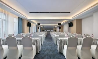 A spacious room at a hotel or conference venue, arranged with rows of tables for an event at Kyriad Marvelous Hotel (Xinyu Jiuding Kongmujiang Store)