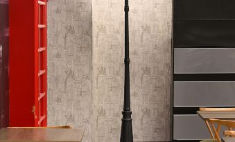a modern office space with red walls , black lamp post , and wooden tables and chairs at Le Room Hotel Taoyuan