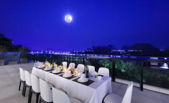 At night, there is a table and chairs on the terrace with a view of the ocean in front at WING HOTEL