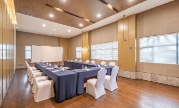a large room arranged for an event, featuring long tables and chairs positioned towards the front at Jinfan Wanyuan Hotel