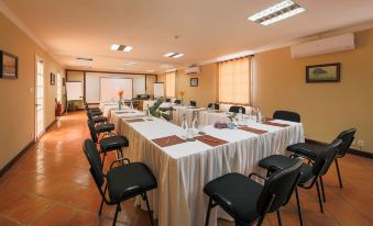 a conference room set up for a meeting , with chairs arranged in a semicircle around a table at Victoria Nui Sam Lodge