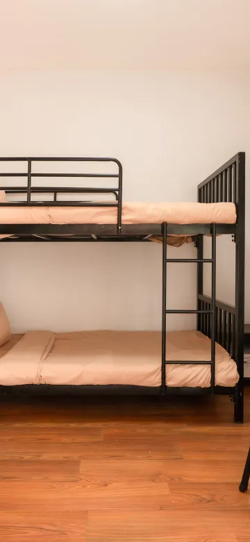 เตียงในห้องพักรวมพร้อมห้องน้ำร่วม