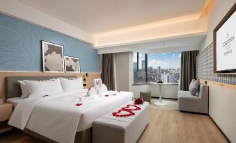 The modern bedroom features large windows, a white bed, and a red accent wall in the middle at Country Inn