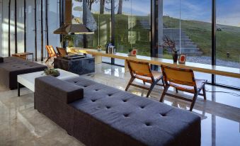 a modern living room with a large couch , two chairs , and a view of the outdoors at The Rock Hotel