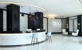 a modern office reception area with black and white marble floors , a curved counter , and a chandelier hanging from the ceiling at Xuzhou Bo'an Hotel (University of Mining and Technology City Subway Station)