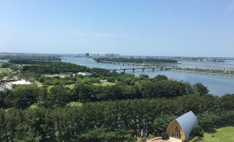 a panoramic view of a city with a river , trees , and buildings , set against a clear blue sky at Grand Mercure Lake Hamana Resort & Spa