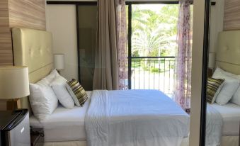 a bedroom with two white beds , one on the left and one on the right side of the room at Sierra Resort
