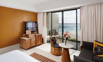 a modern hotel room with a balcony offering an ocean view , featuring wooden furniture and a balcony table at Hard Rock Hotel Maldives - Complimentary Roundtrip Speed Boat Transfer Until 31st October 2025