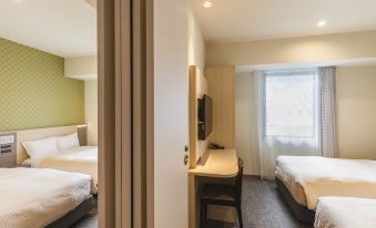 The bedroom features double beds and large sliding doors that open to the other side at Sotetsu Fresa Inn Osaka Namba