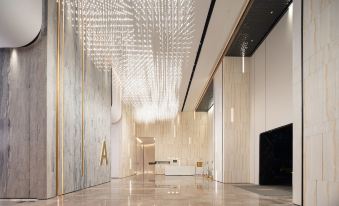 The lobby is adorned with a large, elegant chandelier hanging from the ceiling at Yutai Hotel Apartment (Dongmen Pedestrian Street Luohu Port Branch)