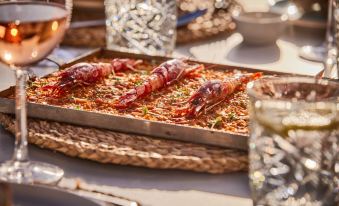 a dining table with a variety of food items , including shrimp on a bed of rice at Universal Hotel Aquamarin