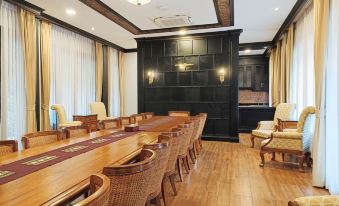 a large dining room with a long wooden table and multiple chairs arranged around it at Lanna Resort Chiang Mai