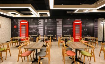 a modern restaurant with wooden tables and chairs , black walls , and a red phone booth at Le Room Hotel Taoyuan