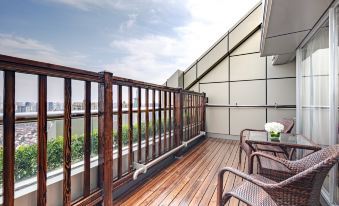 The apartment in Jaffna features a spacious balcony with chairs and a table on the deck at Radisson Collection Hotel, Yangtze Shanghai