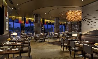 a large dining room with multiple tables and chairs arranged for a group of people to enjoy a meal at Crown Metropol Perth