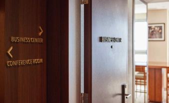 "a door with a sign that says "" business center "" and an arrow pointing to the right" at Lotte City Hotel Ulsan