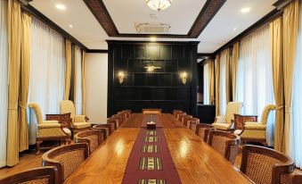 a long wooden table with chairs and a red runner is set up in front of a black wall at Lanna Resort Chiang Mai