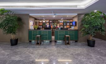 An upscale hotel features a lobby or reception area with tables and chairs at Hongge Apartment Hotel