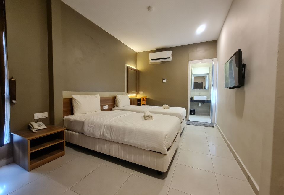 a modern hotel room with two beds , a tv , and a bathroom , all neatly arranged at Ants Hotel