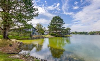 a serene lake with a small island in the middle , surrounded by houses and trees at Pine Lake Resort