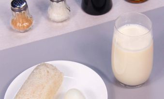 A plate with food and ingredients, including a glass of milk, for making the dish at Autoongo Hotel On the Bund, Shanghai