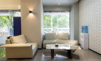 The living room features two couches and an open window, accompanied by a coffee table at Yueta X E-sports Hotel (Jiangnanxi Subway Station)