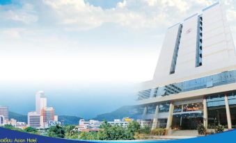 a large white building with a blue and gold color scheme , situated on a hill overlooking a city at Asian Hotel